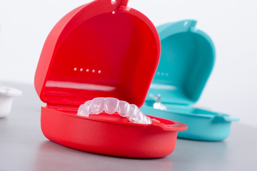 Red container holding Invisalign clear aligner.