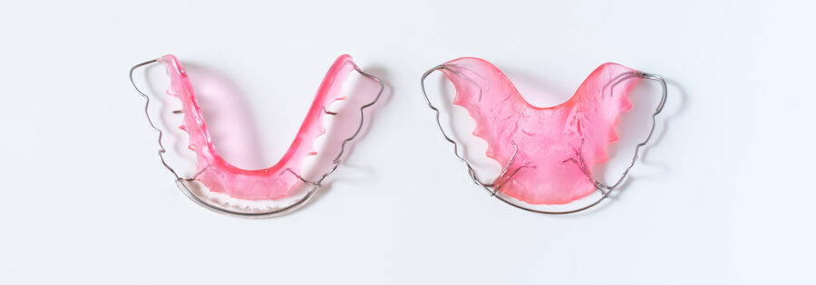 Aerial view of pink removable orthodontic retainers to keep teeth in place