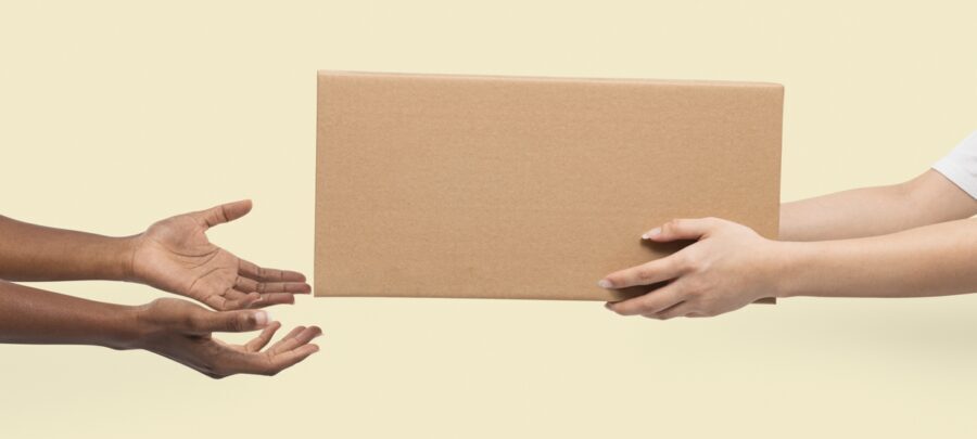 Closeup of hands delivering a brown box to another pair of hands
