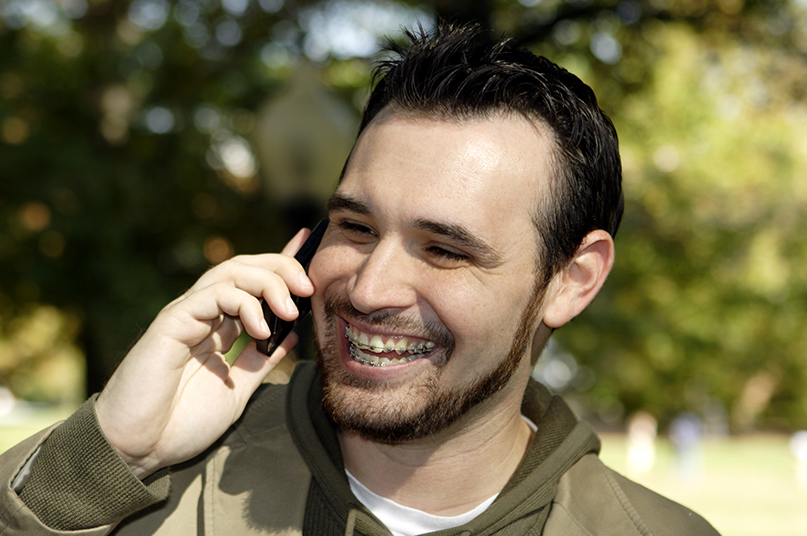 man with braces on the phone
